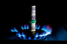 natural gas flame with rolled money inside, gas prices concept