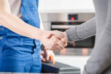 friendly home technician shaking hands with homeowner