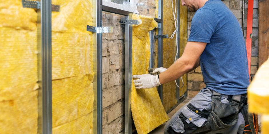 technician installing insulation in basement