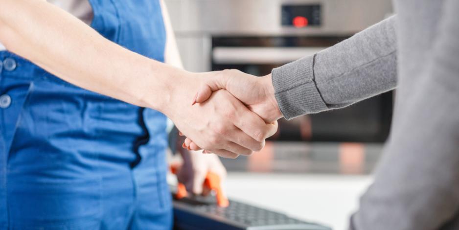 friendly home technician shaking hands with homeowner